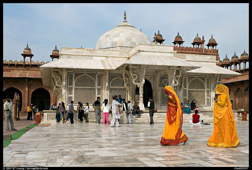 Two women walking outside the white marble  Shaikh Salim Chishti tomb. Fatehpur Sikri, Uttar Pradesh, India