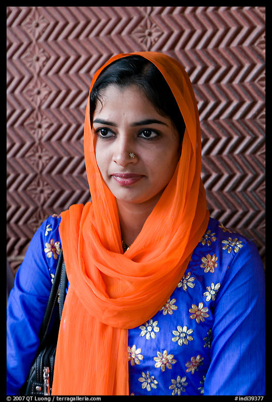 Young woman with bright scarf, in front of Rumi Sultana motifs. Fatehpur Sikri, Uttar Pradesh, India