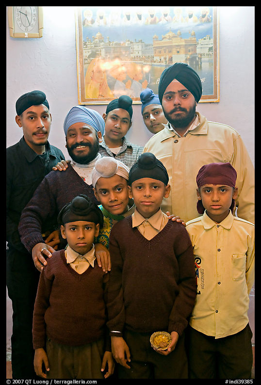 Sikh men and boys in front of picture of the Golden Temple. Bharatpur, Rajasthan, India