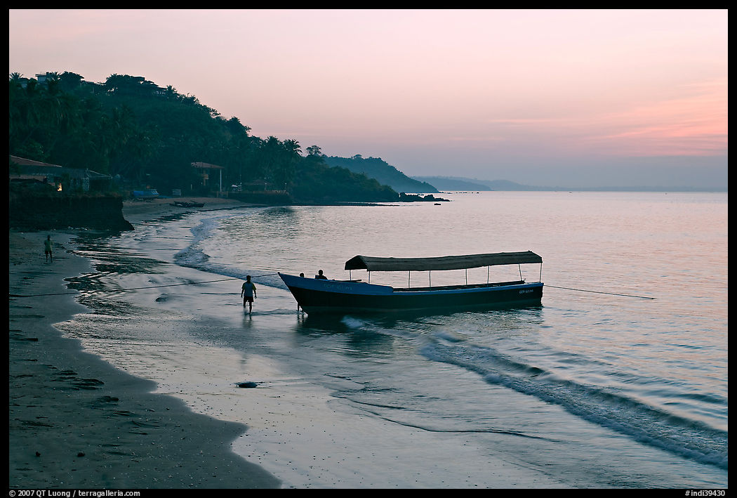 Narrow boat on beach at dawn, Dona Paula. Goa, India