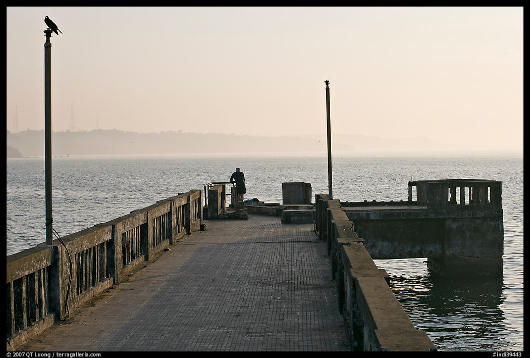 Pier with man fishing, early morning, Dona Paula. Goa, India