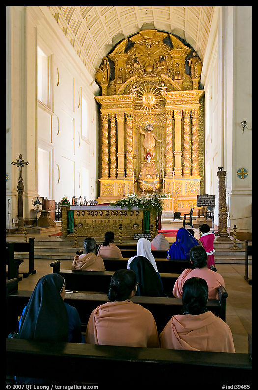 Indian women sitting in front of the altar, Basilica of Bom Jesus, Old Goa. Goa, India