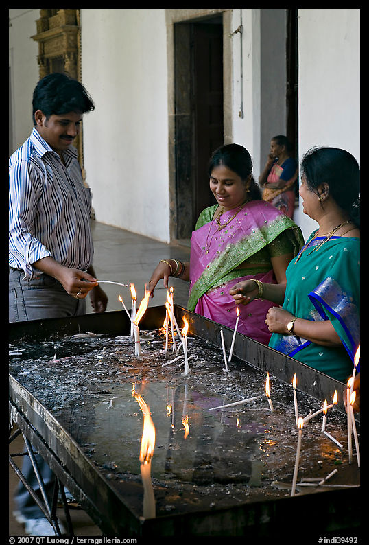 Man and two women burning candles, Basilica of Bom Jesus, Old Goa. Goa, India