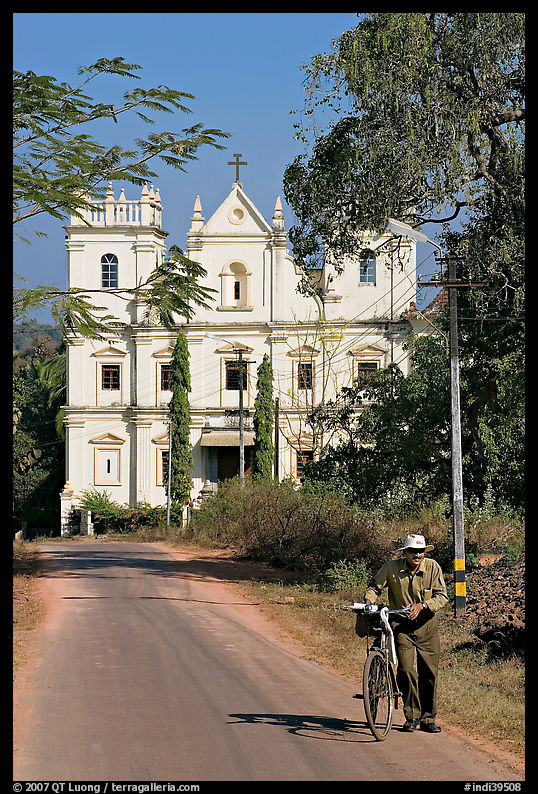 Man walking a bicycle in front of church of St John, Old Goa. Goa, India