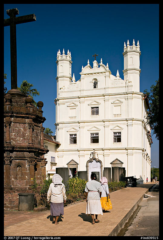 Women walking towards Church of St Francis of Assisi, afternoon, Old Goa. Goa, India