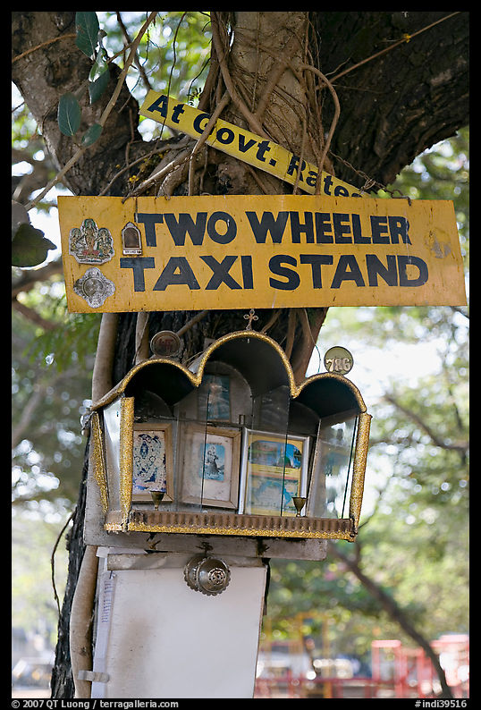 Two wheeler taxi stand and altar on tree. Goa, India