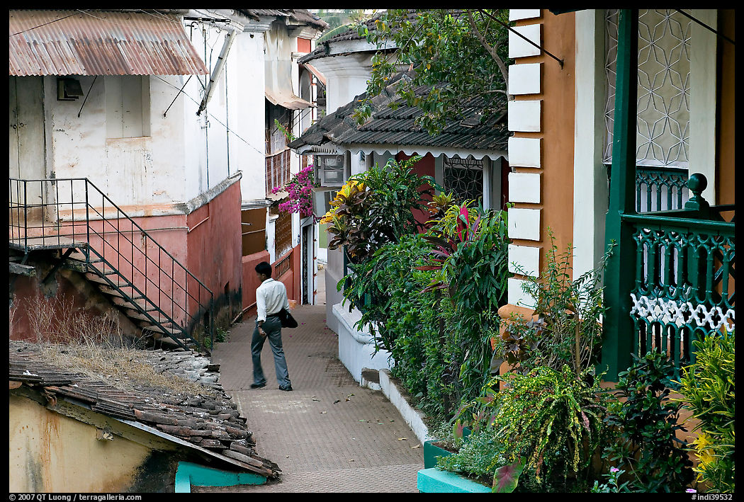 Man in alley with gardens, Panjim. Goa, India