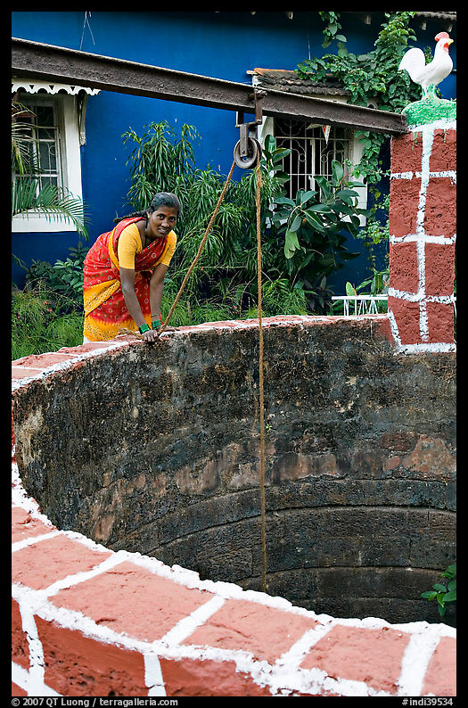 Woman retrieving water from well, Panaji. Goa, India
