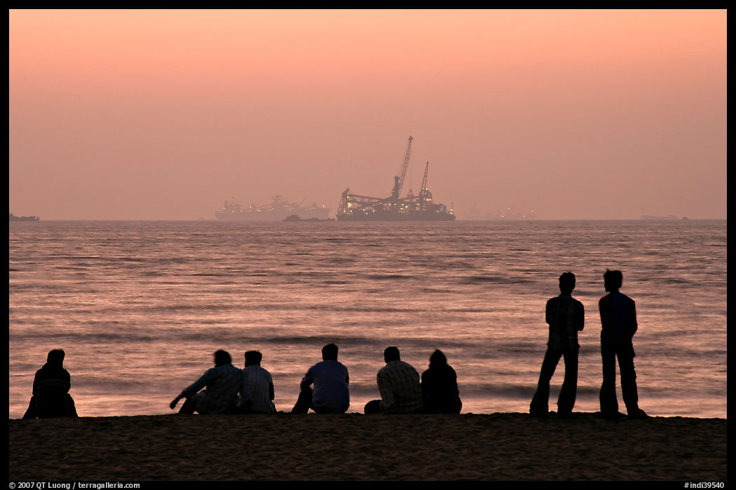 People and  off-shore platforms, Miramar Beach, sunset. Goa, India
