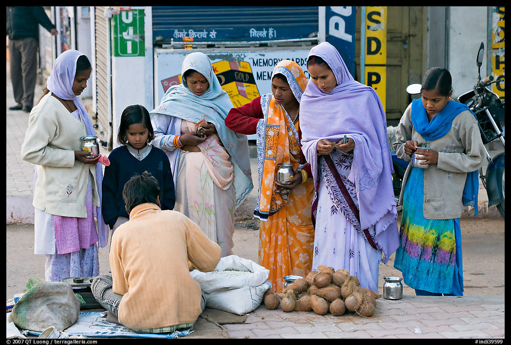 Hindu women purchasing offerings before going to temple. Khajuraho, Madhya Pradesh, India