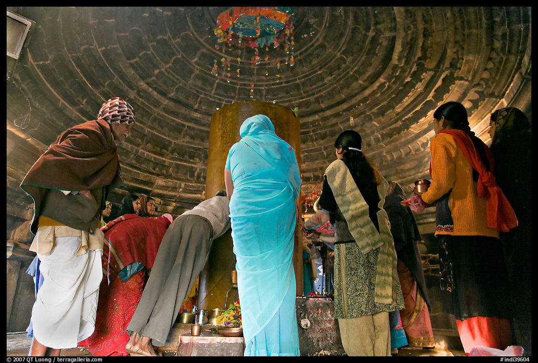 Worshipers and polished lingam inside Matangesvara temple. Khajuraho, Madhya Pradesh, India