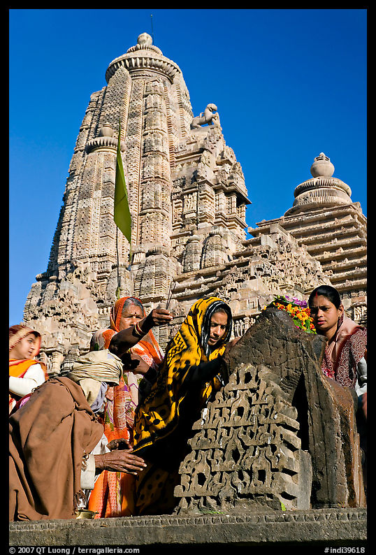 Hindu worshippers making offerings with Lakshmana temple behind. Khajuraho, Madhya Pradesh, India