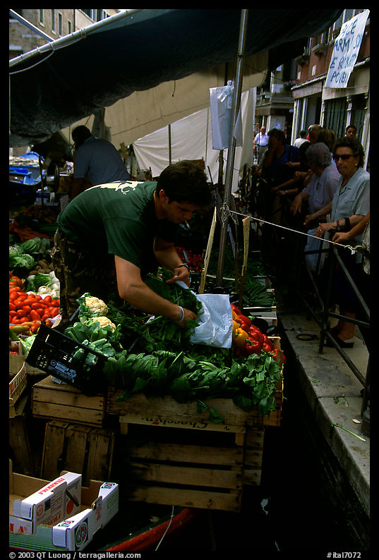 Selling fruit and vegetable from a boat on a small  canal, Castello. Venice, Veneto, Italy