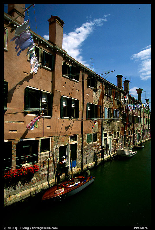 Resident stepping from his doorway to his boat,  Castello. Venice, Veneto, Italy