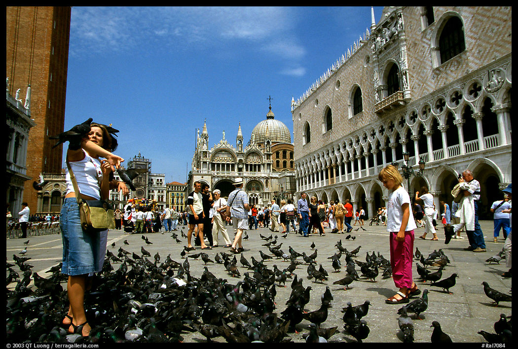Visitors feeding the pigeons, Piazzetta San Marco (Square Saint Mark), mid-day. Venice, Italy