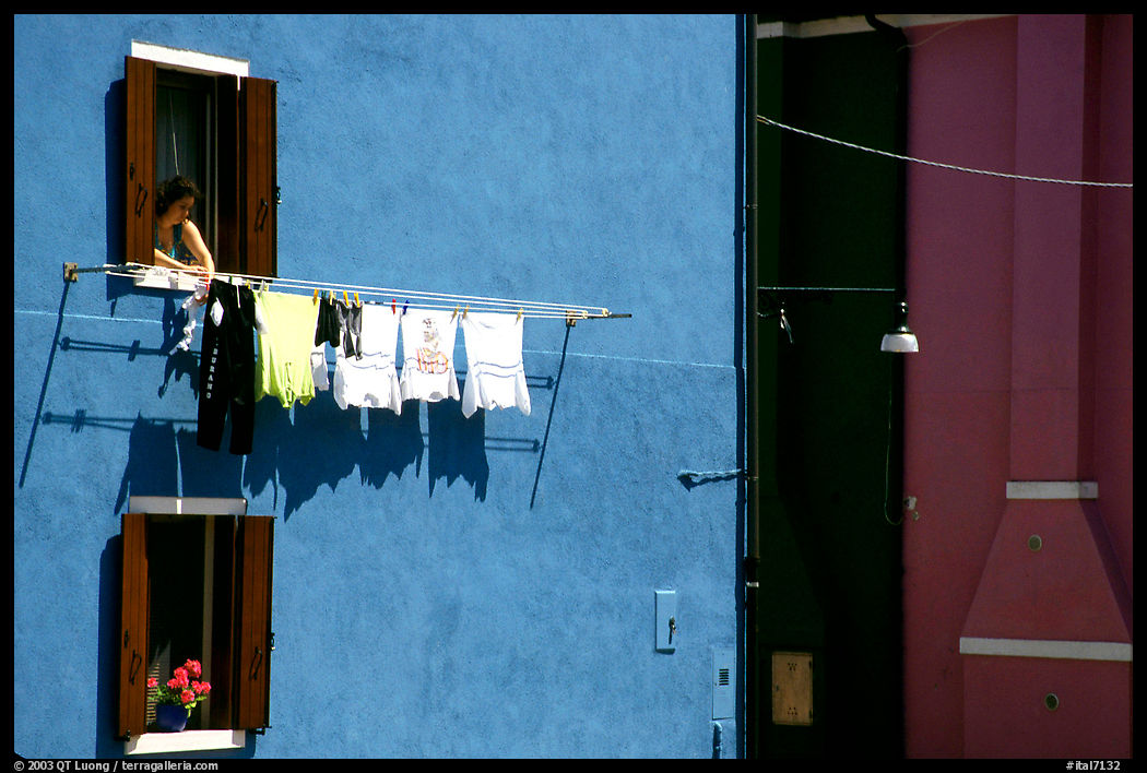 Woman hangs laundry to dry, Burano. Venice, Italy