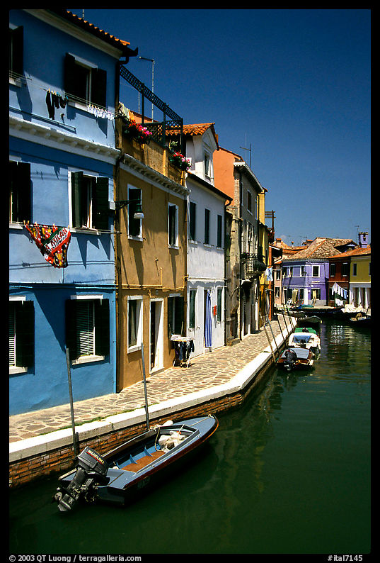 Canal lined with houses painted with a multitude of bright colors, Burano. Venice, Italy