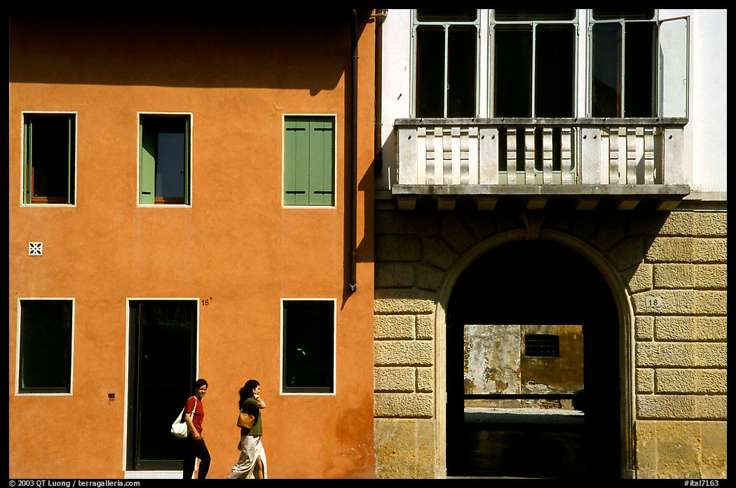 Women walking along a street. Veneto, Italy