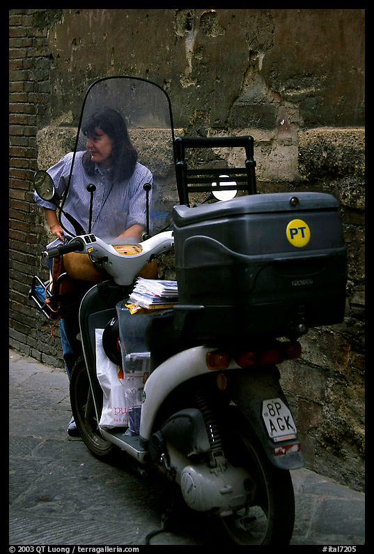 Delivering mail from a scooter. Siena, Tuscany, Italy