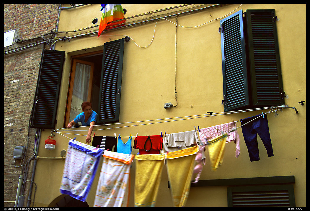 Woman hanging laundry. Siena, Tuscany, Italy