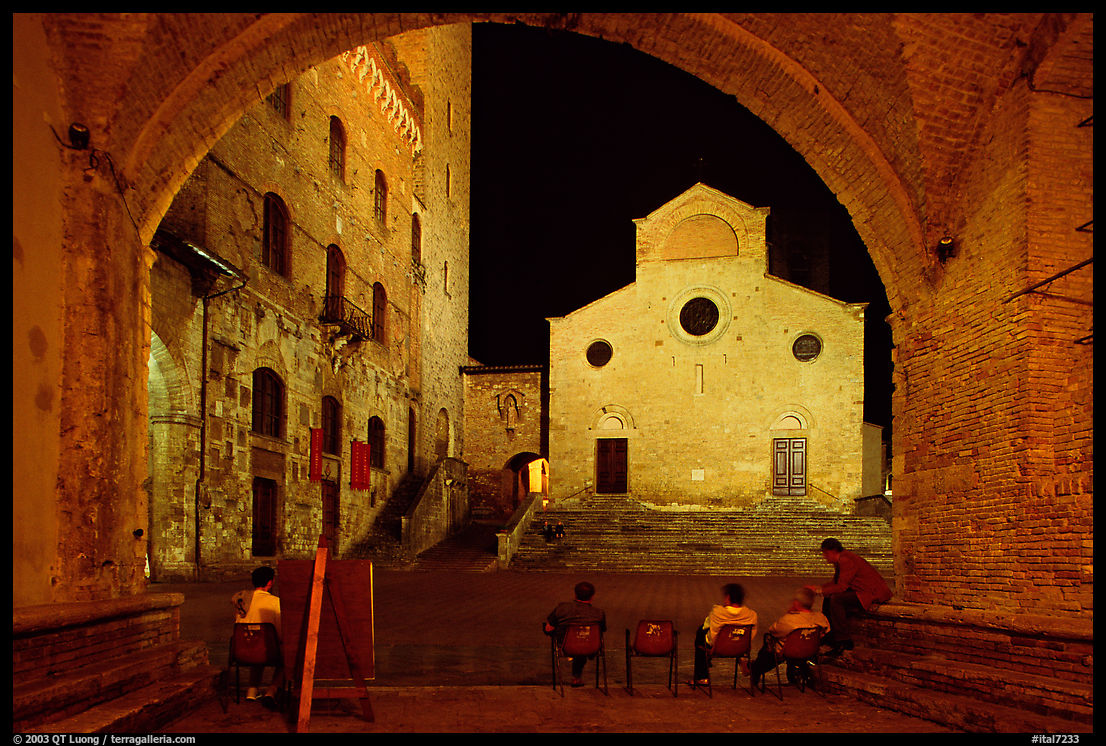 Duomo framed by an arch at night. San Gimignano, Tuscany, Italy
