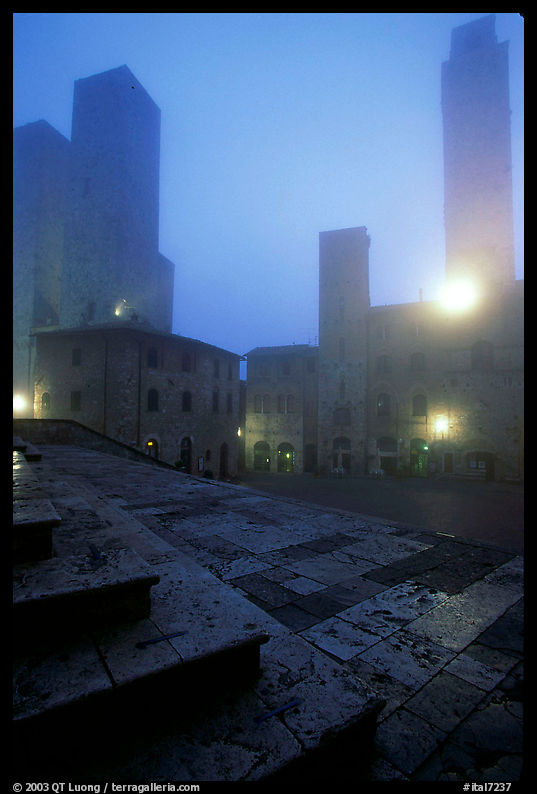 Piazza del Duomo at dawn in the fog. San Gimignano, Tuscany, Italy