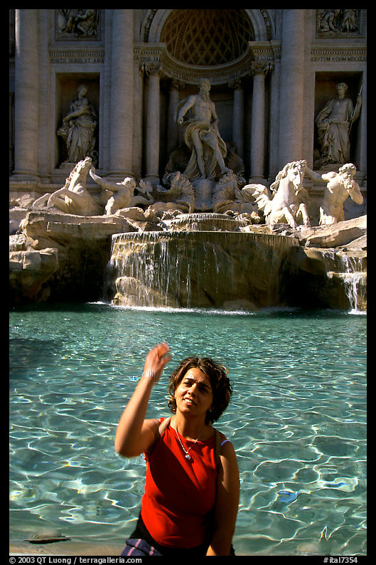 Visitor tosses a coin over her shoulder in the Trevi Fountain. Rome, Lazio, Italy