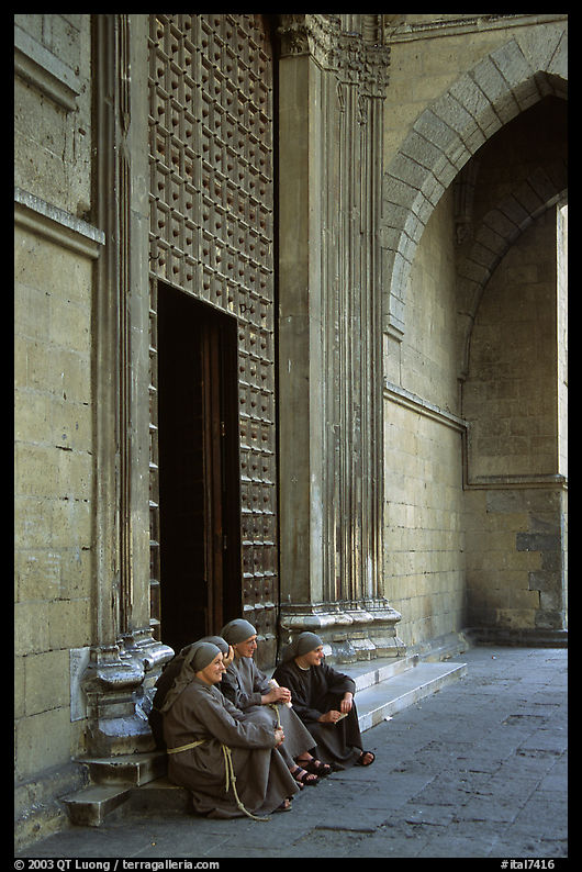 Nuns sit outside of one of  many churches of the historic town. Naples, Campania, Italy