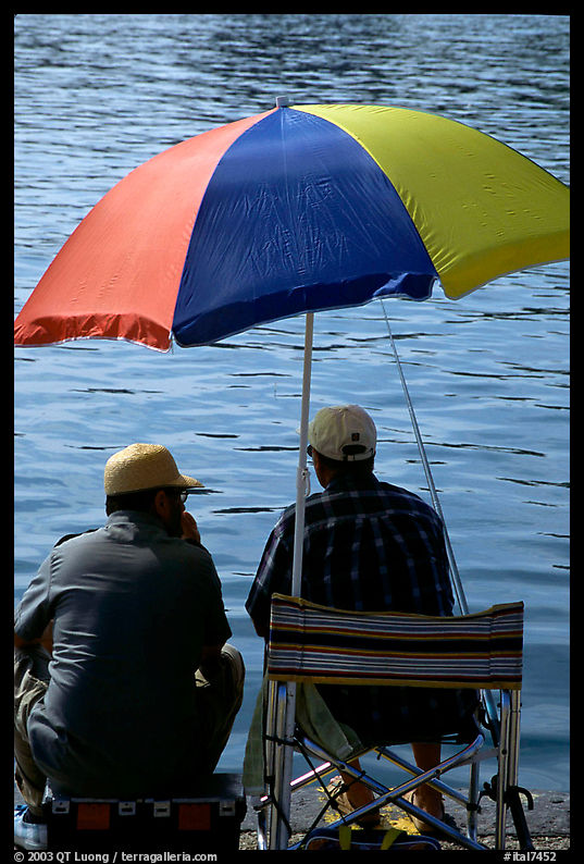 Men fishing under an unbrella,  Agropoli. Campania, Italy