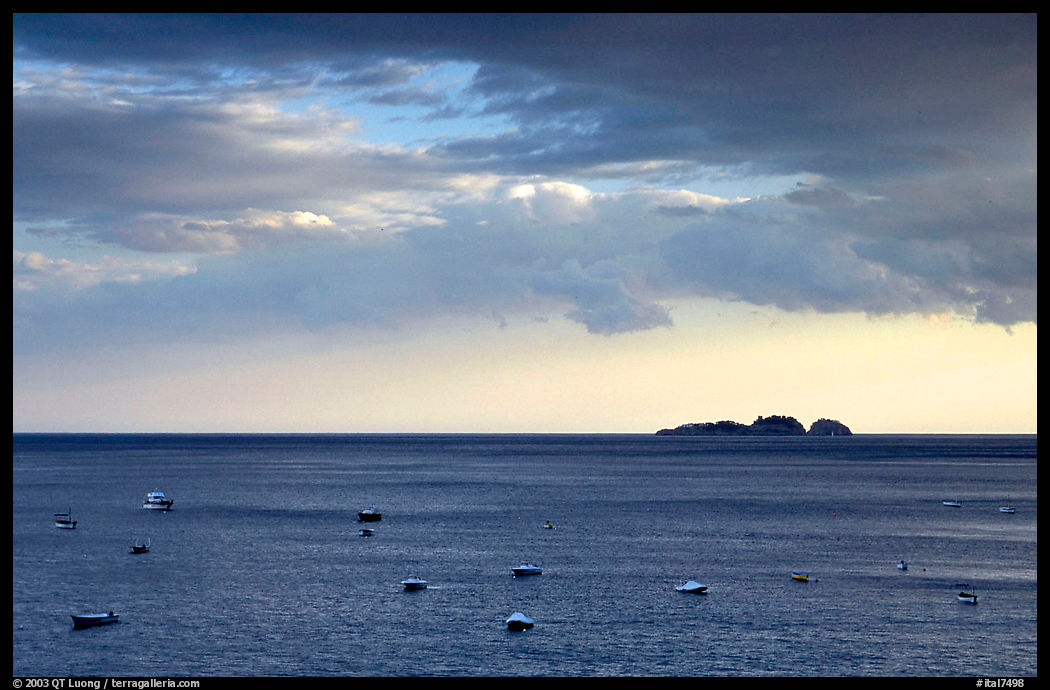 Small boats and Capri Island at sunset, Positano. Amalfi Coast, Campania, Italy