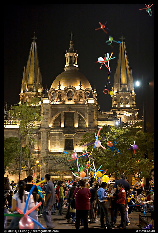 Children play with inflated balloons behind the Cathedral by night. Guadalajara, Jalisco, Mexico