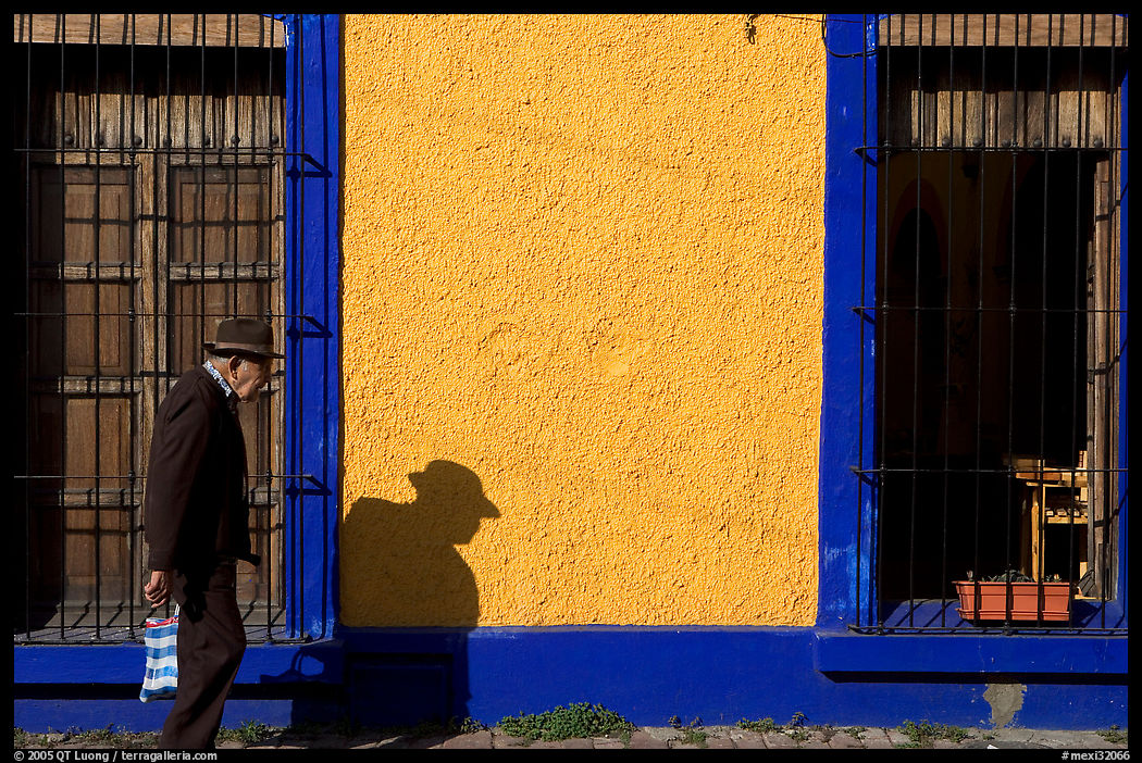 Elderly man walking along a colorful wall, Tlaquepaque. Jalisco, Mexico
