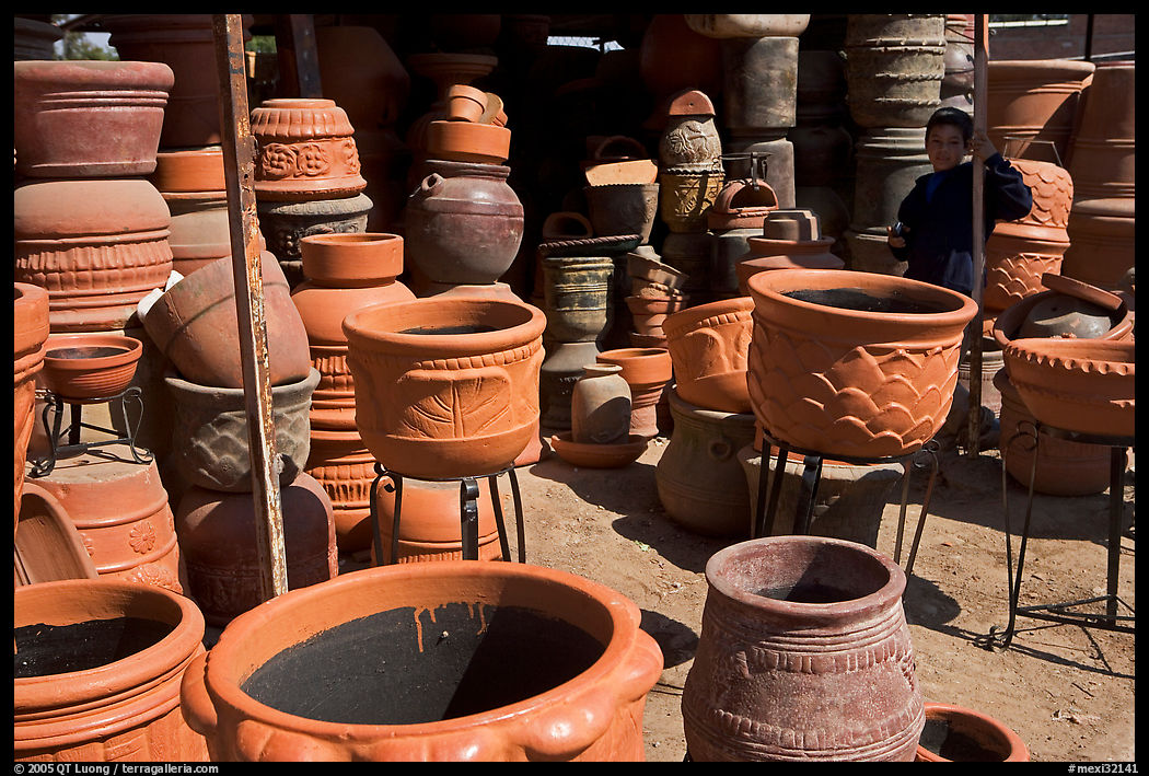 Boy standing next to clay pots, Tonala. Jalisco, Mexico