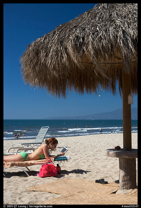 Woman in swimsuit reading on beach chair, Nuevo Vallarta, Nayarit. Jalisco, Mexico