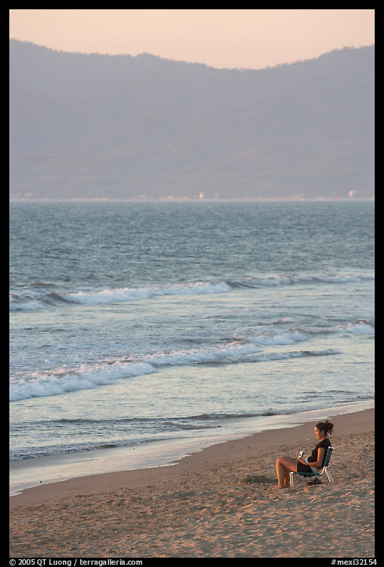 Woman sitting on the beach looking at the sunset, Nuevo Vallarta, Nayarit. Jalisco, Mexico