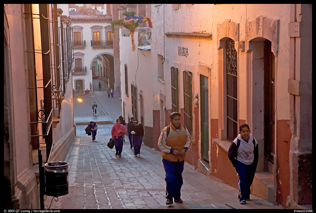 Children heading to school up a narrow cajaon, dawn. Zacatecas, Mexico
