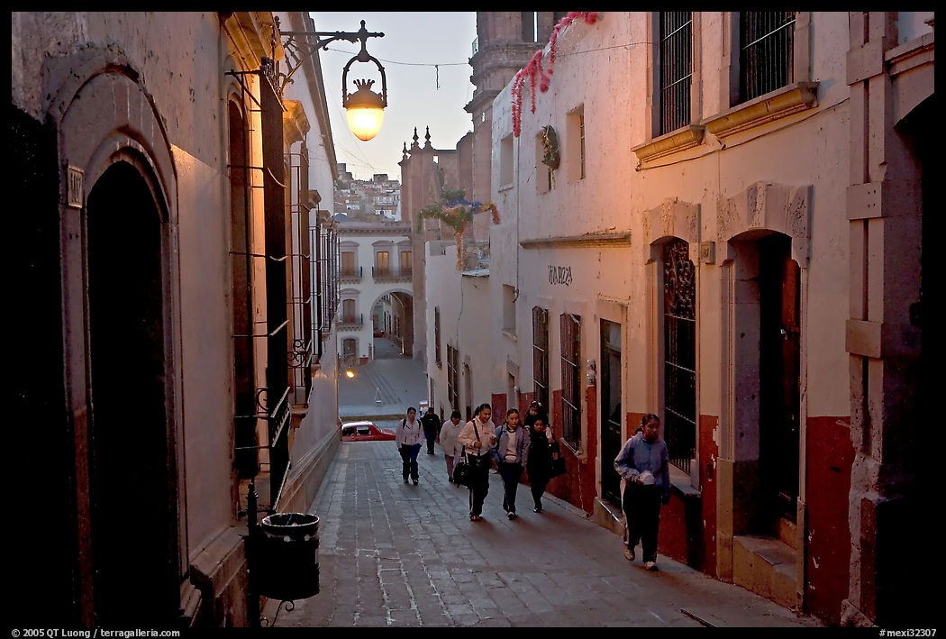 Children heading to school up a narrow cajaon, dawn. Zacatecas, Mexico