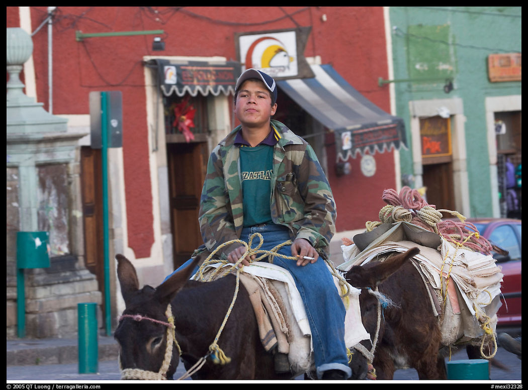 Young man riding a donkey in the streets. Guanajuato, Mexico