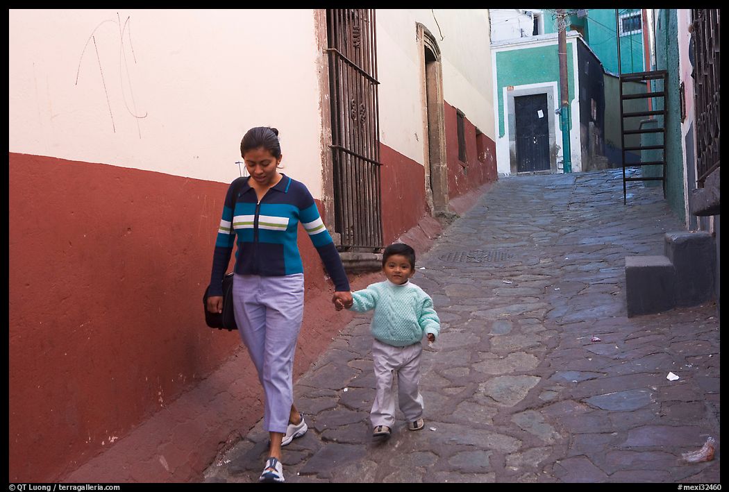 Woman and boy walking down an alleyway. Guanajuato, Mexico