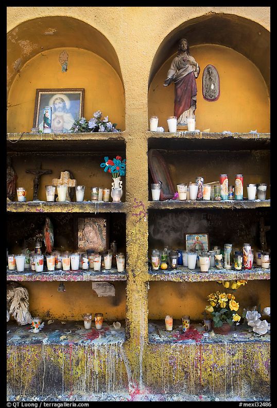 Candles, flowers, and religious offerings in a roadside chapel. Mexico