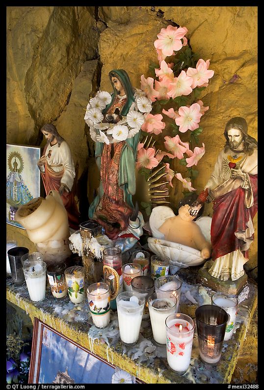 Religious figures and candles in roadside chapel. Mexico