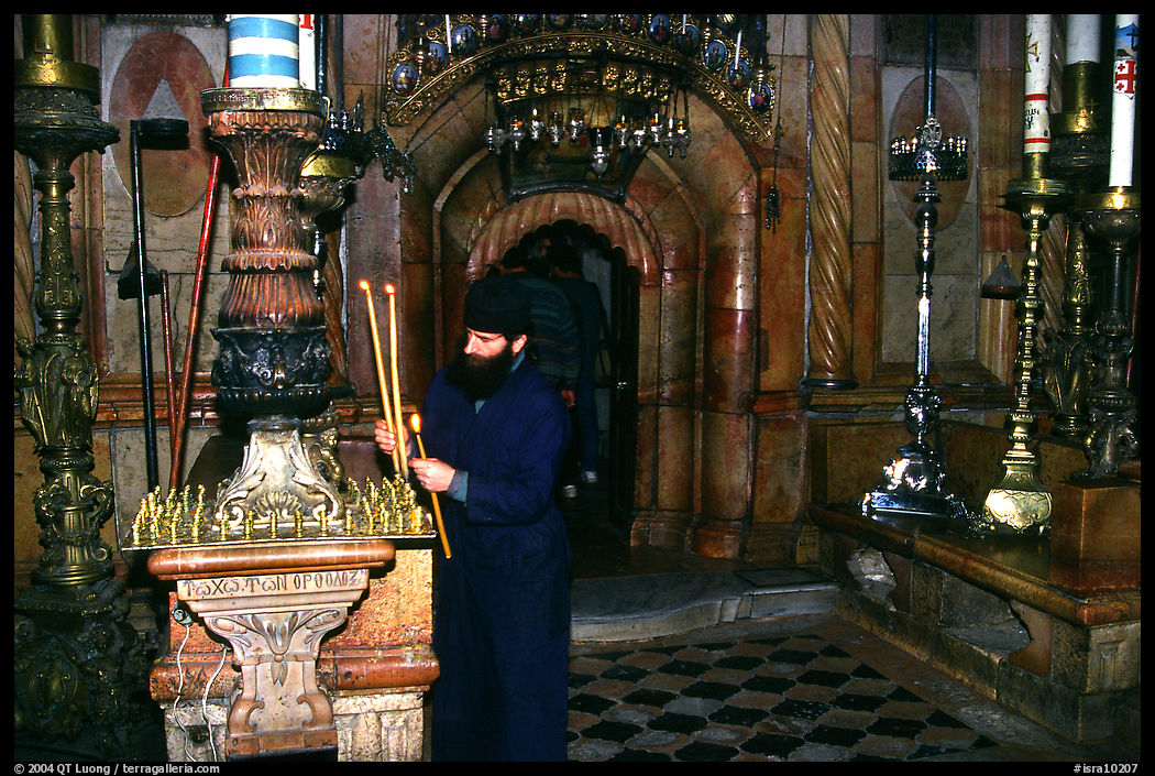 Christian Orthodox priest lighting candles. Jerusalem, Israel
