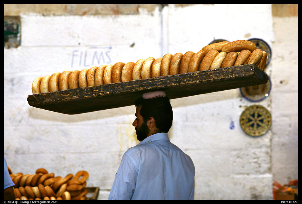 Man carrying many loafes of bread on his head. Jerusalem, Israel
