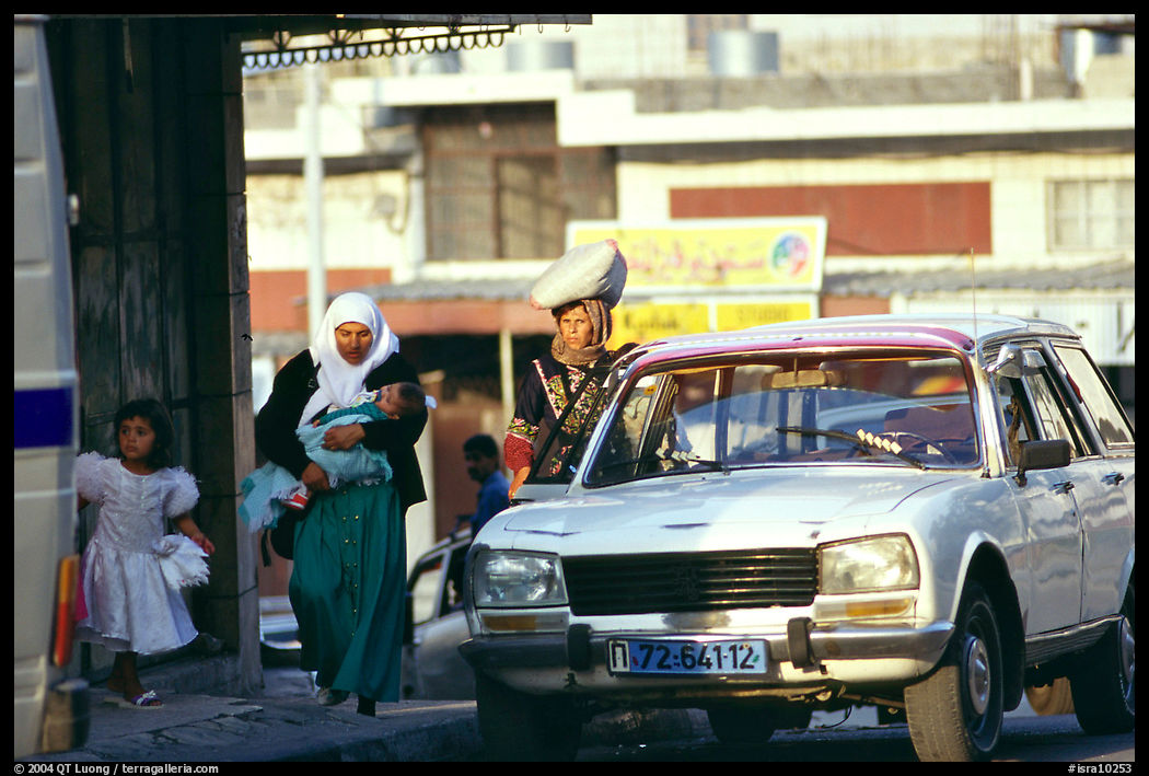 Women next to an old French Peugeot car, Hebron. West Bank, Occupied Territories (Israel)