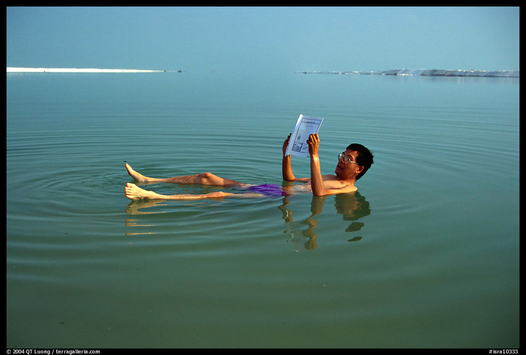 Visitor reading while floating in the Dead Sea. Israel