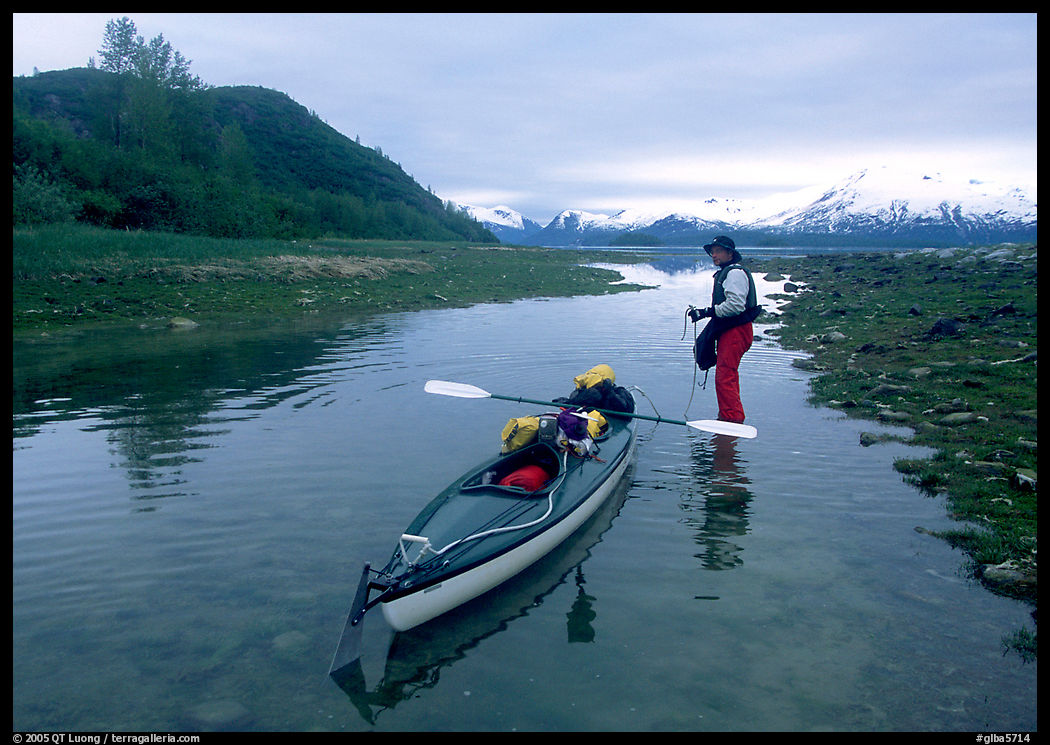 Kayaker tows kayak into a shallow tidal channel into Scidmore Bay. Glacier Bay National Park, Alaska