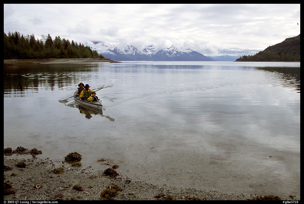 Kayakers paddle a double kayak in Hugh Miller Inlet. Glacier Bay National Park, Alaska