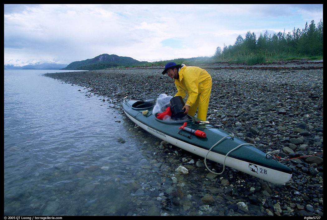 Kayaker unloading gear from a double kayak. Glacier Bay National Park, Alaska