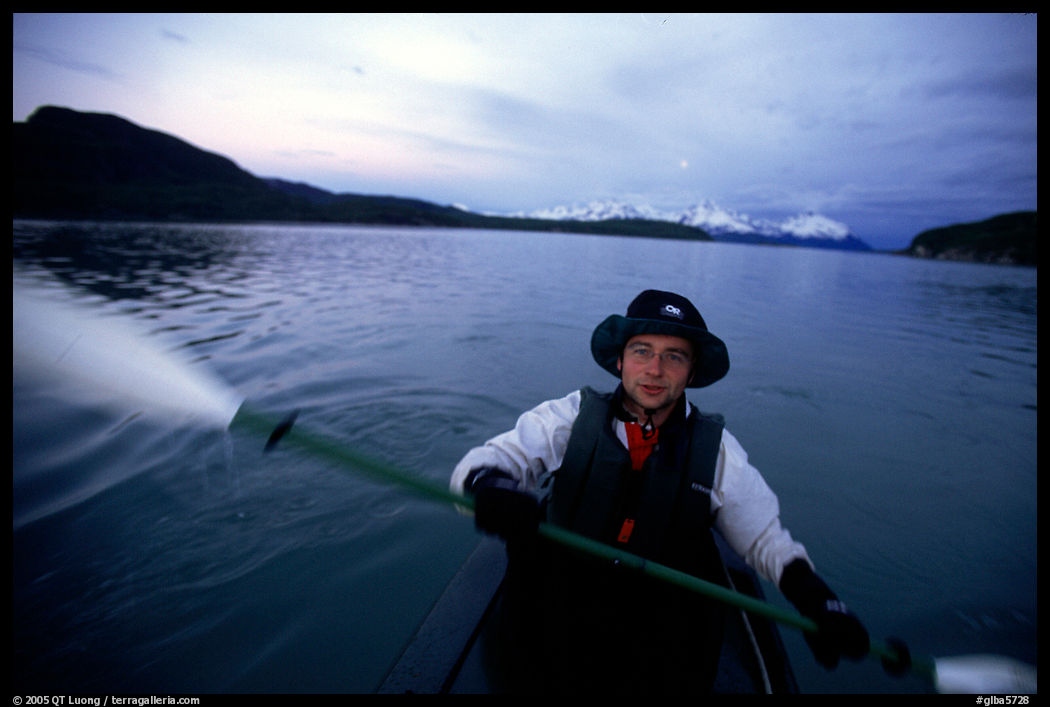 Kayaker paddling in Muir Inlet at midnight. Glacier Bay National Park, Alaska