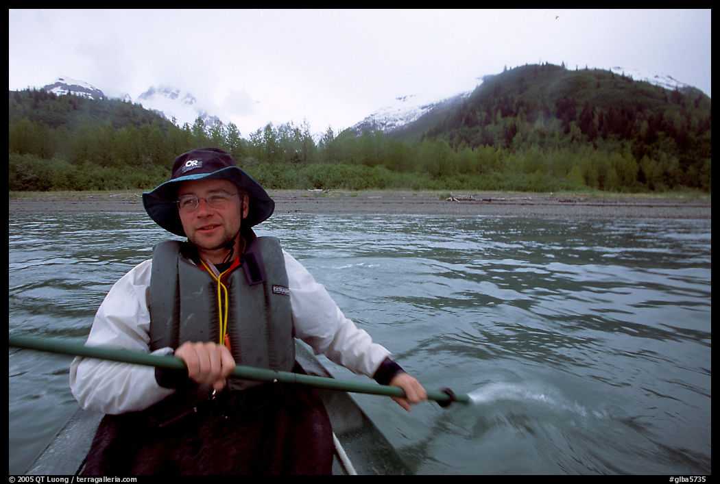 Kayaker paddling away from shore in Muir Inlet. Glacier Bay National Park, Alaska